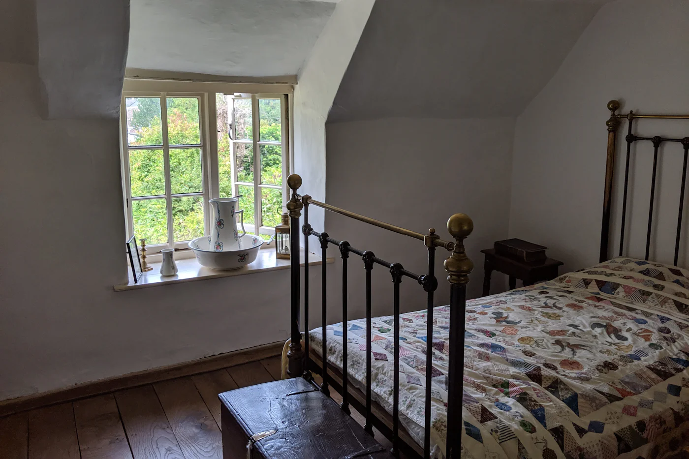Main bedroom with a vintage iron bedstead beneath a cottage window