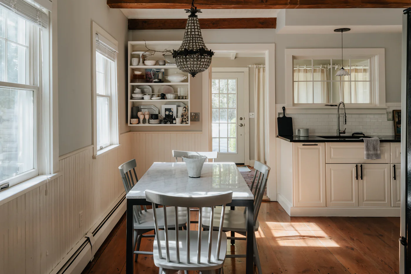 Kitchen dining table with chairs beside a bright window