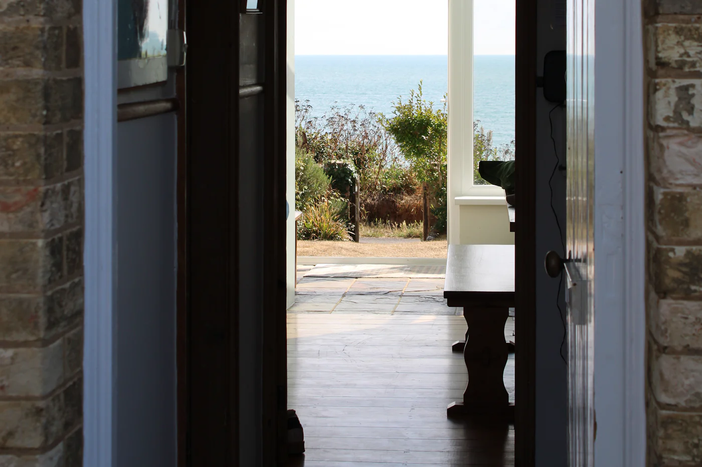 Open back door looking out across the garden to the sea